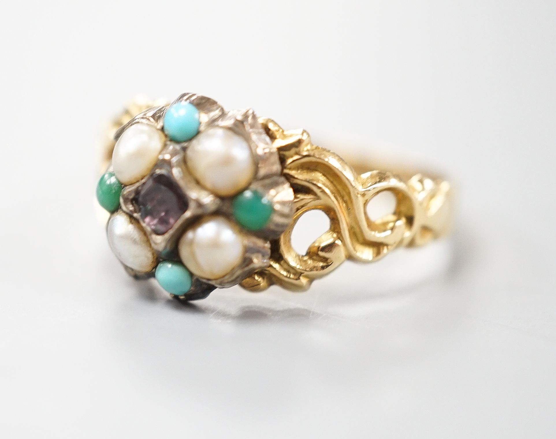 A late Victorian yellow metal, garnet, turquoise and split pearl cluster set dress ring, size M, gross weight 2.9 grams.